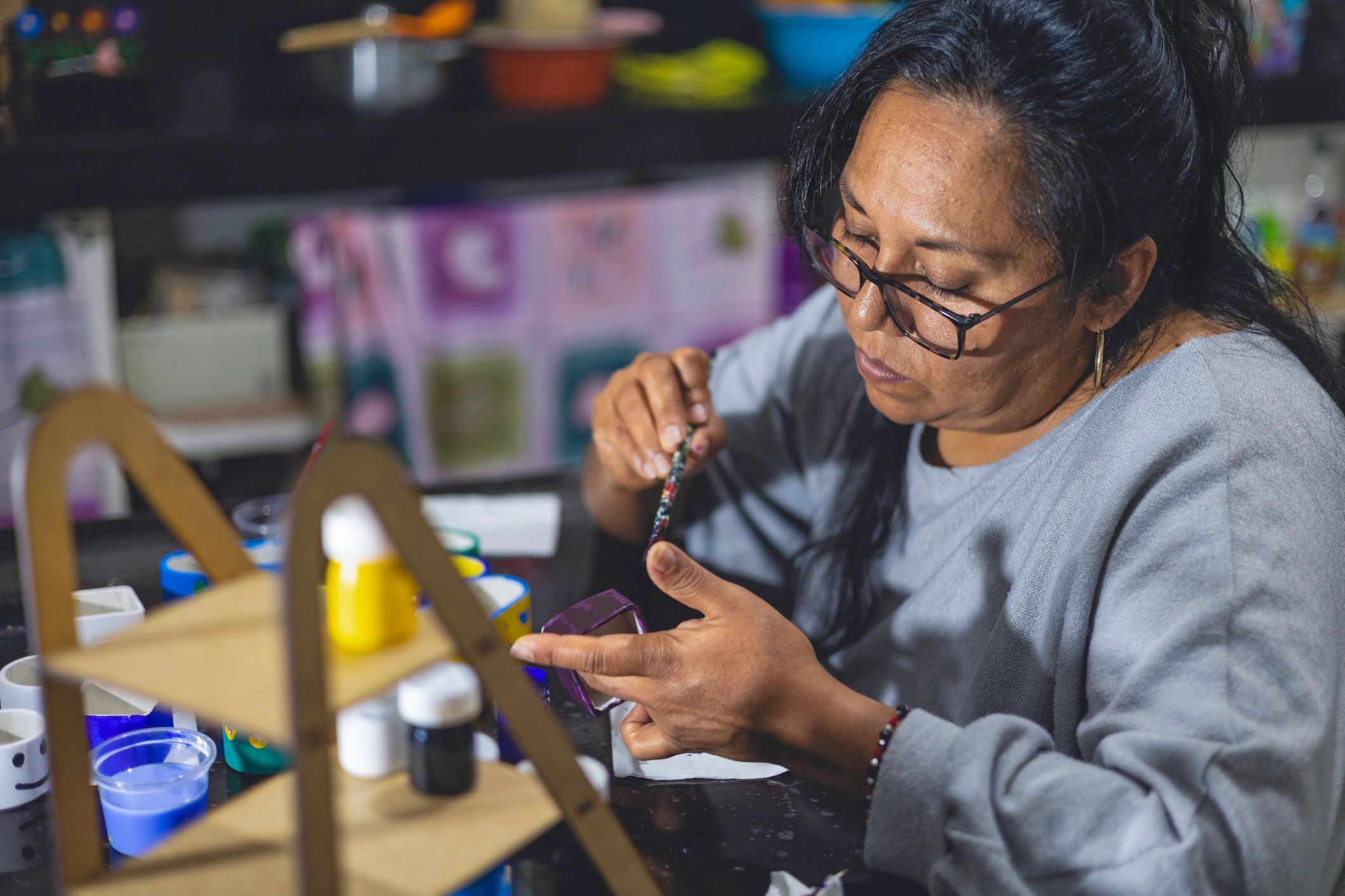 Latina artisan painting a ceramic piece in a craft studio
